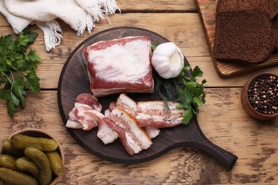 Flat lay composition of pork fatback and ingredients on wooden table