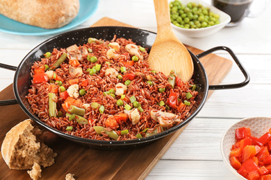 Photo of Tasty brown rice with vegetables on white wooden table