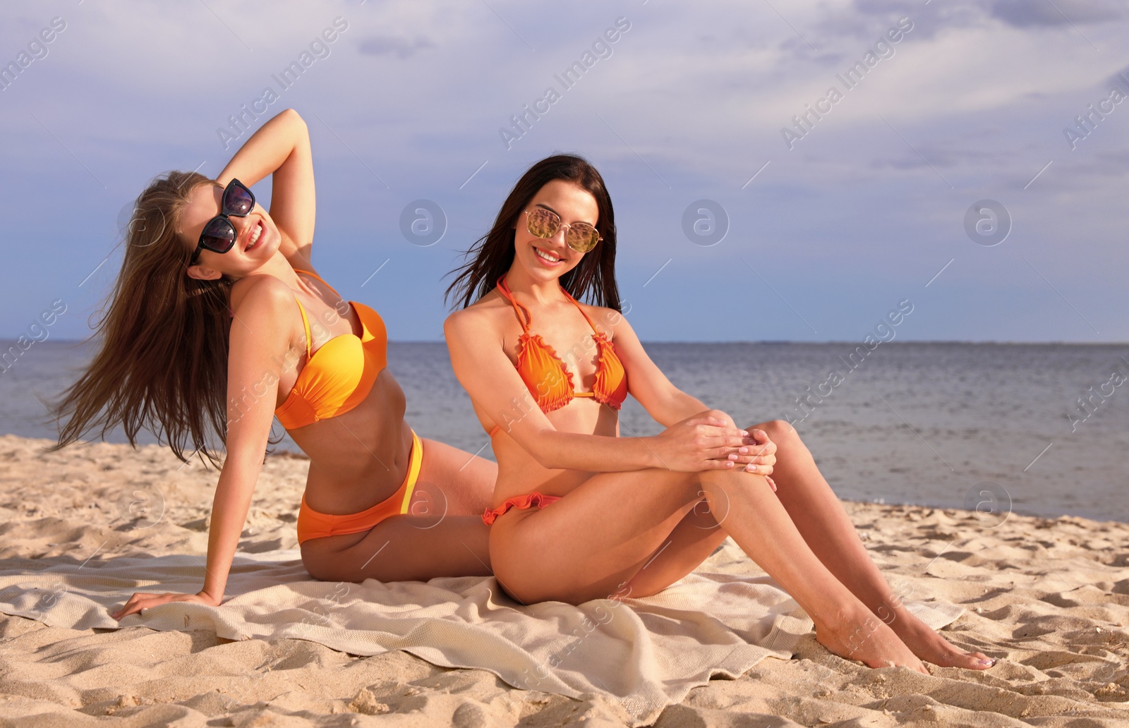 Photo of Young couple in bikini spending time together on beach