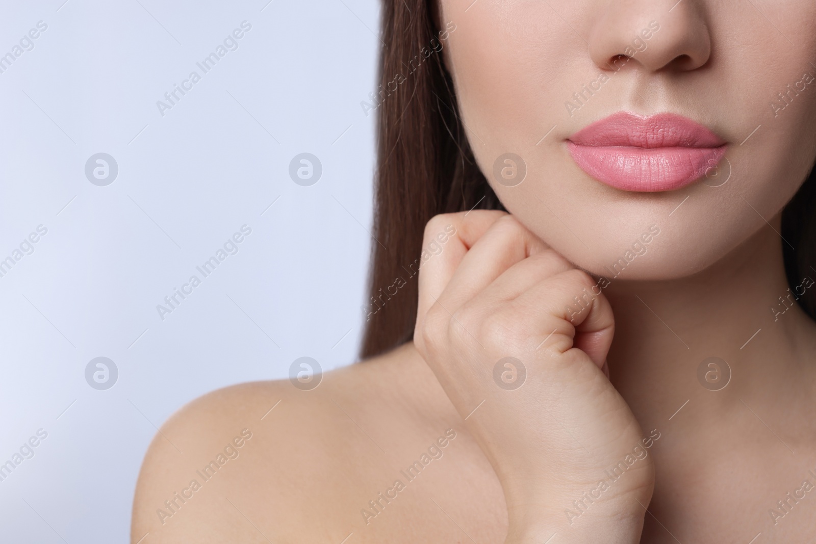 Photo of Closeup view of woman with beautiful full lips on light background. Space for text