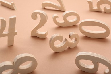 Many different wooden numbers on beige background