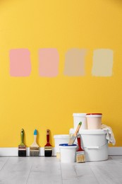 Image of Set with decorator tools and paint on floor near color wall