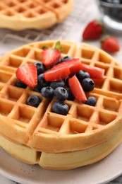 Photo of Tasty Belgian waffles with fresh berries on table, closeup