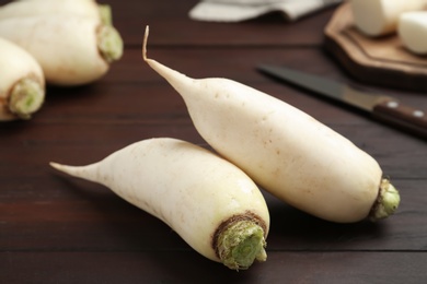 Raw white turnips on brown wooden table, closeup