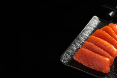 Photo of Delicious salmon sashimi on black background, closeup. Space for text