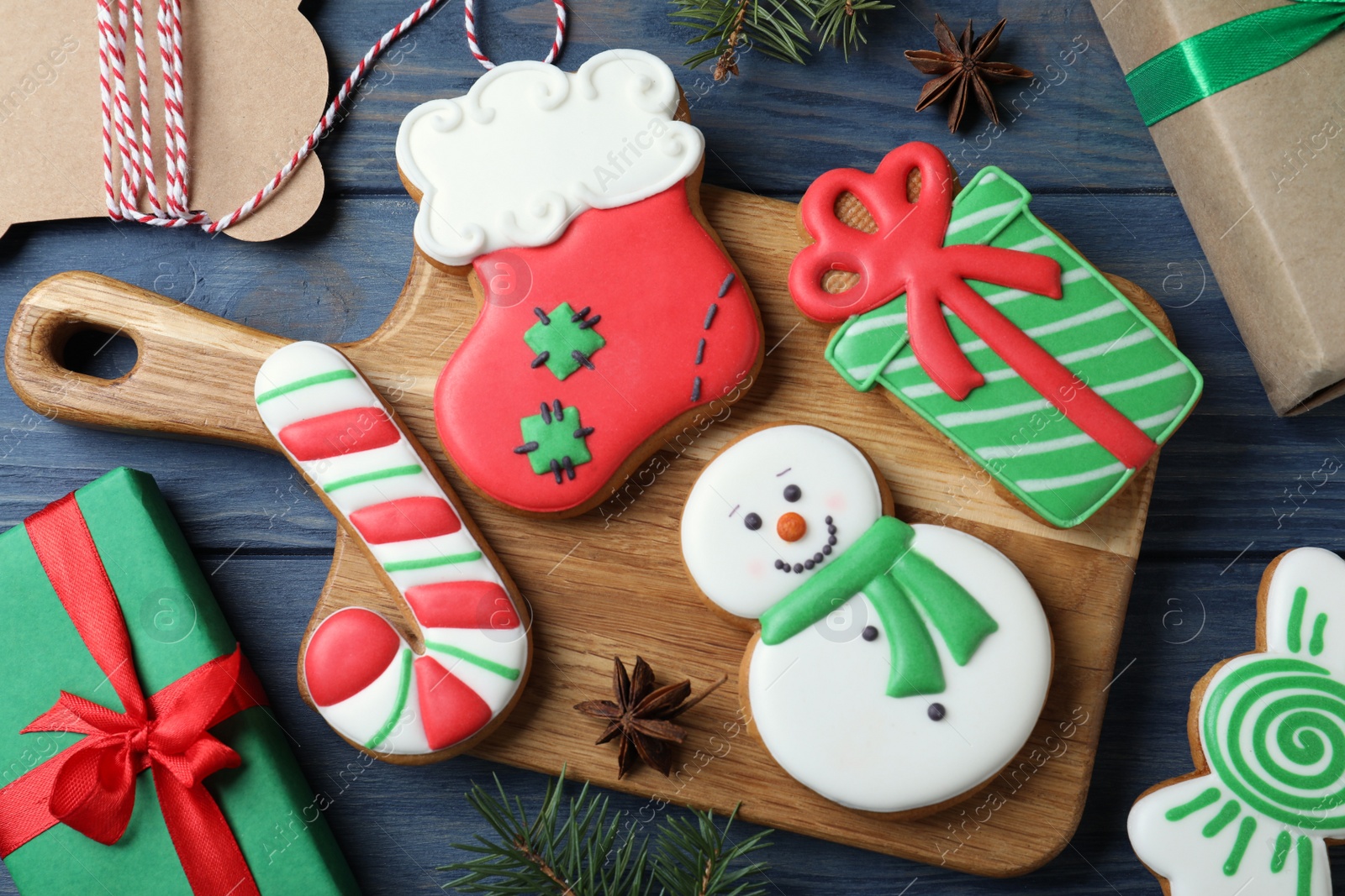 Photo of Decorated Christmas cookies on blue wooden table, flat lay