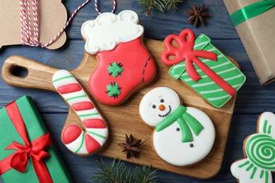 Photo of Decorated Christmas cookies on blue wooden table, flat lay