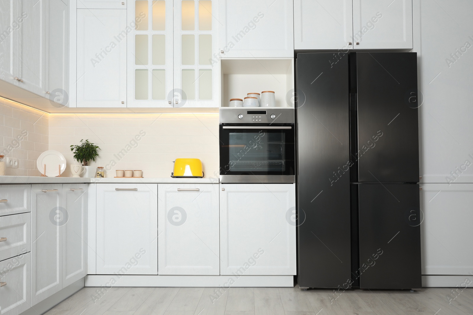 Photo of Stylish kitchen interior with modern steel refrigerator