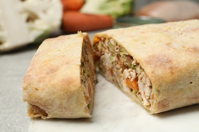 Photo of Delicious strudel with chicken and vegetables on light table, closeup