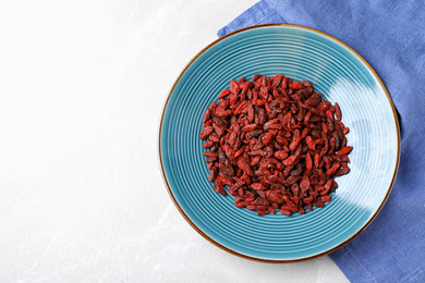 Photo of Dried goji berries on white table, top view. Space for text