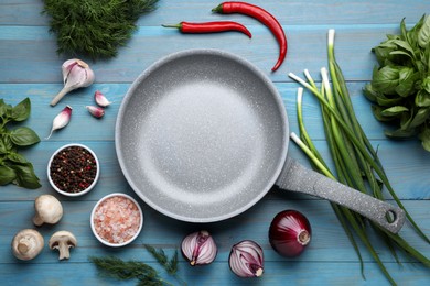 Flat lay composition with frying pan and fresh products on light blue wooden table