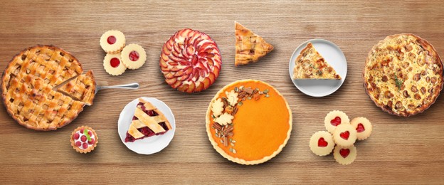 Image of Flat lay composition with different delicious pies on wooden table. Banner design