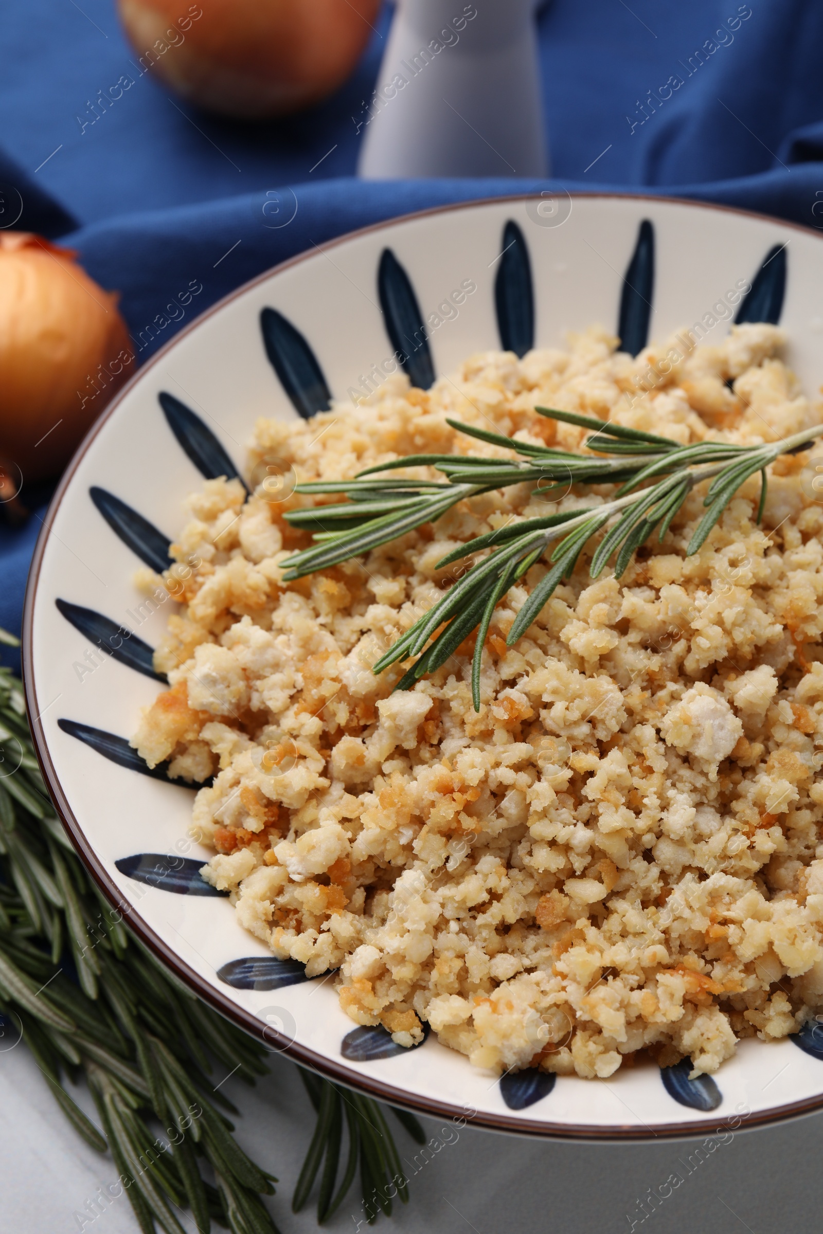 Photo of Fried ground meat in bowl and rosemary on table, closeup