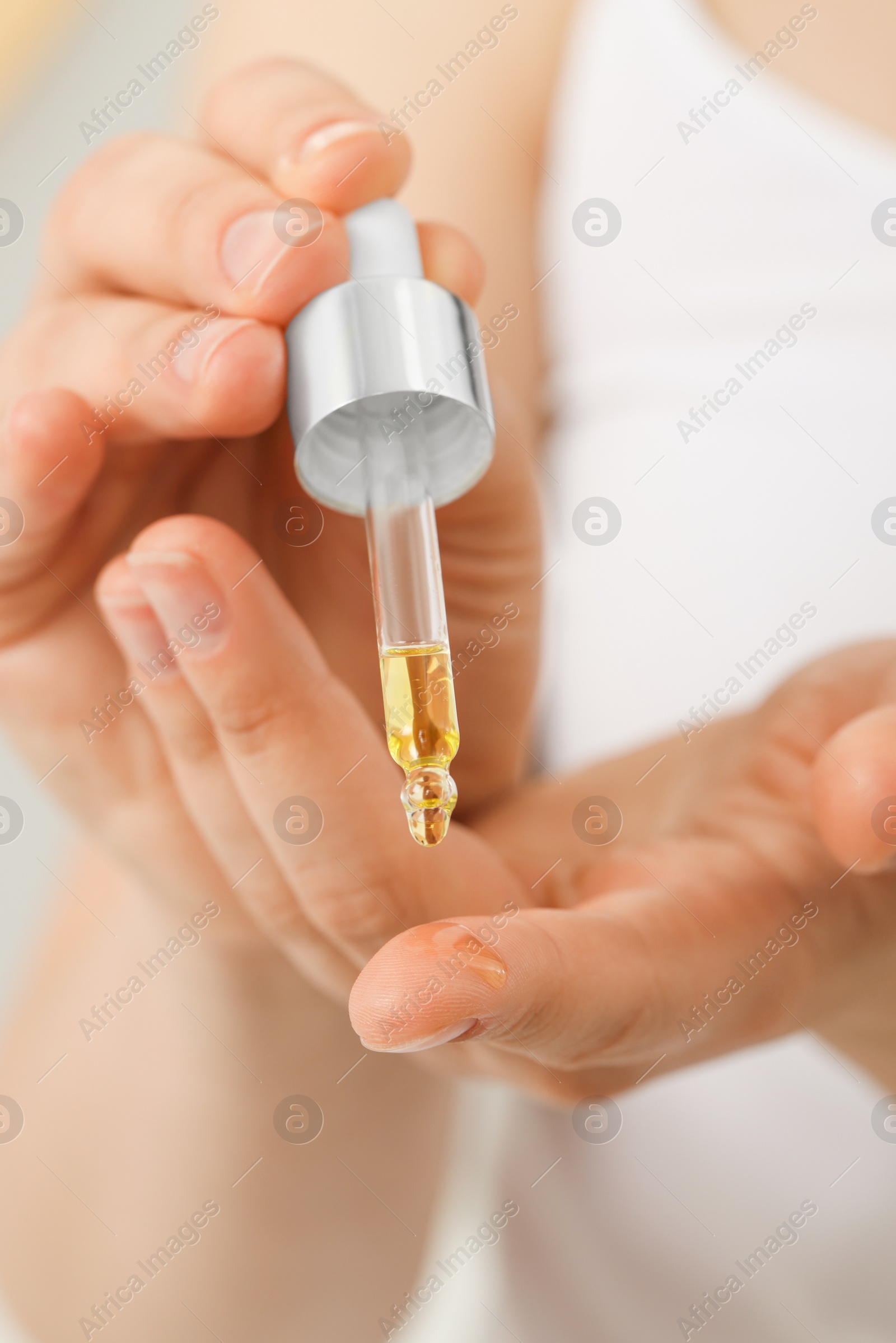 Photo of Woman applying essential oil onto hand, closeup