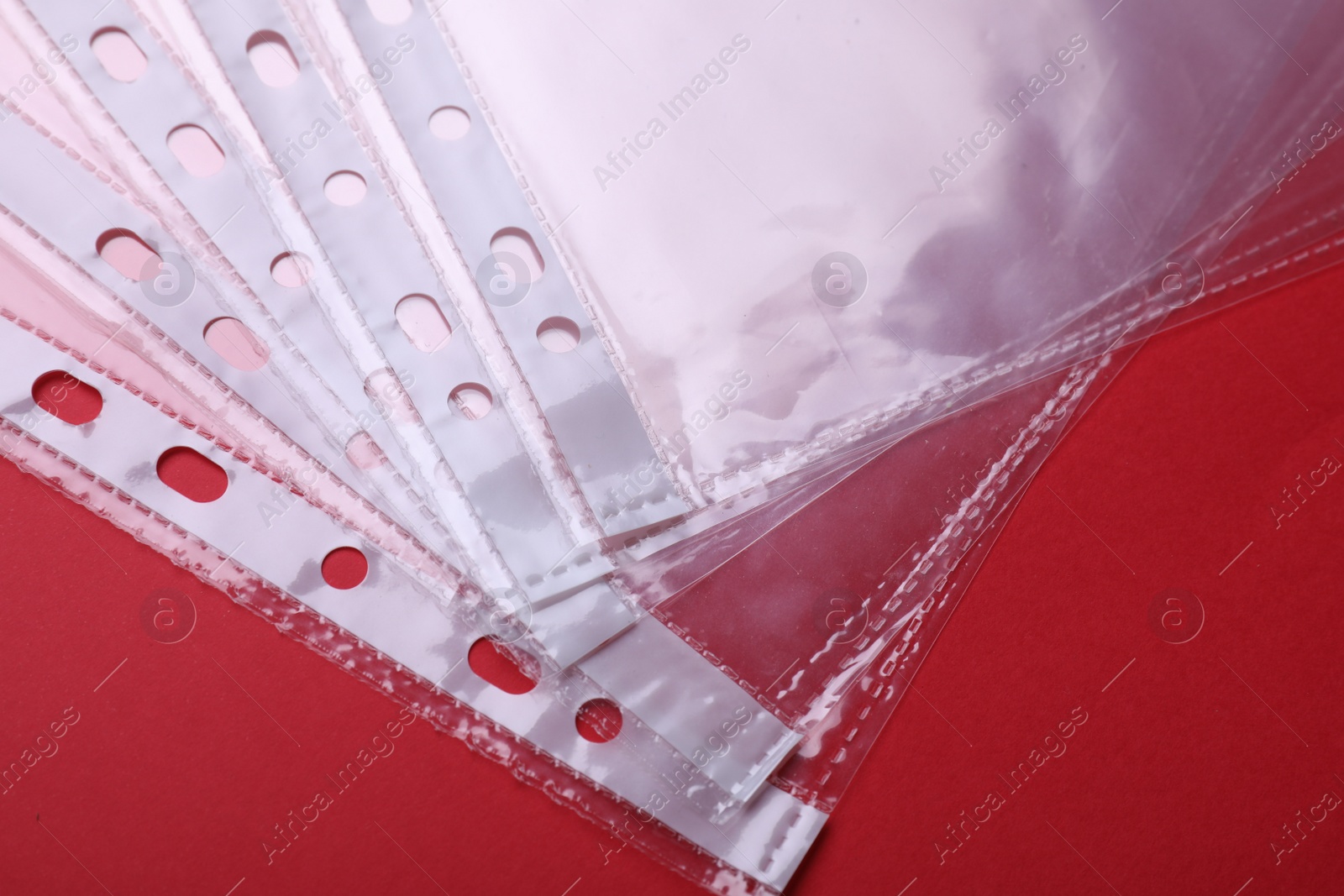 Photo of Empty punched pockets on red background, flat lay