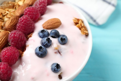 Photo of Tasty homemade granola served on blue wooden table, closeup. Healthy breakfast