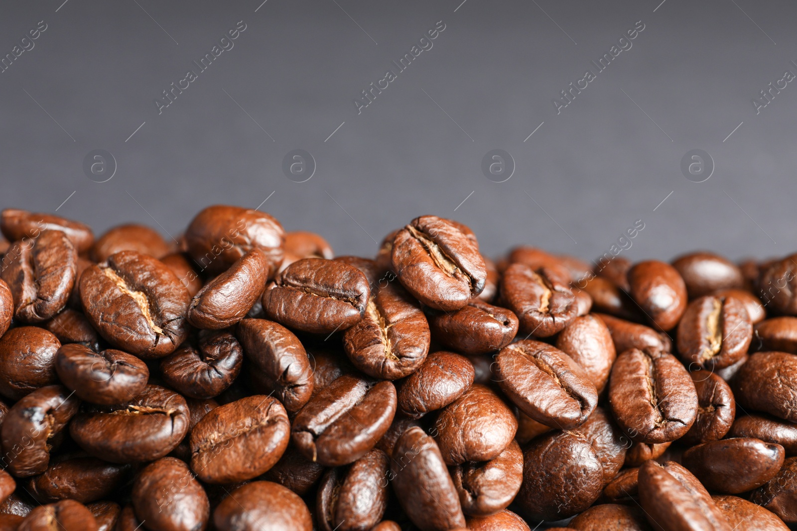 Photo of Roasted coffee beans on grey background, closeup