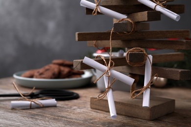 Photo of Advent calendar with rolled paper sheets on wooden table, closeup. Space for text