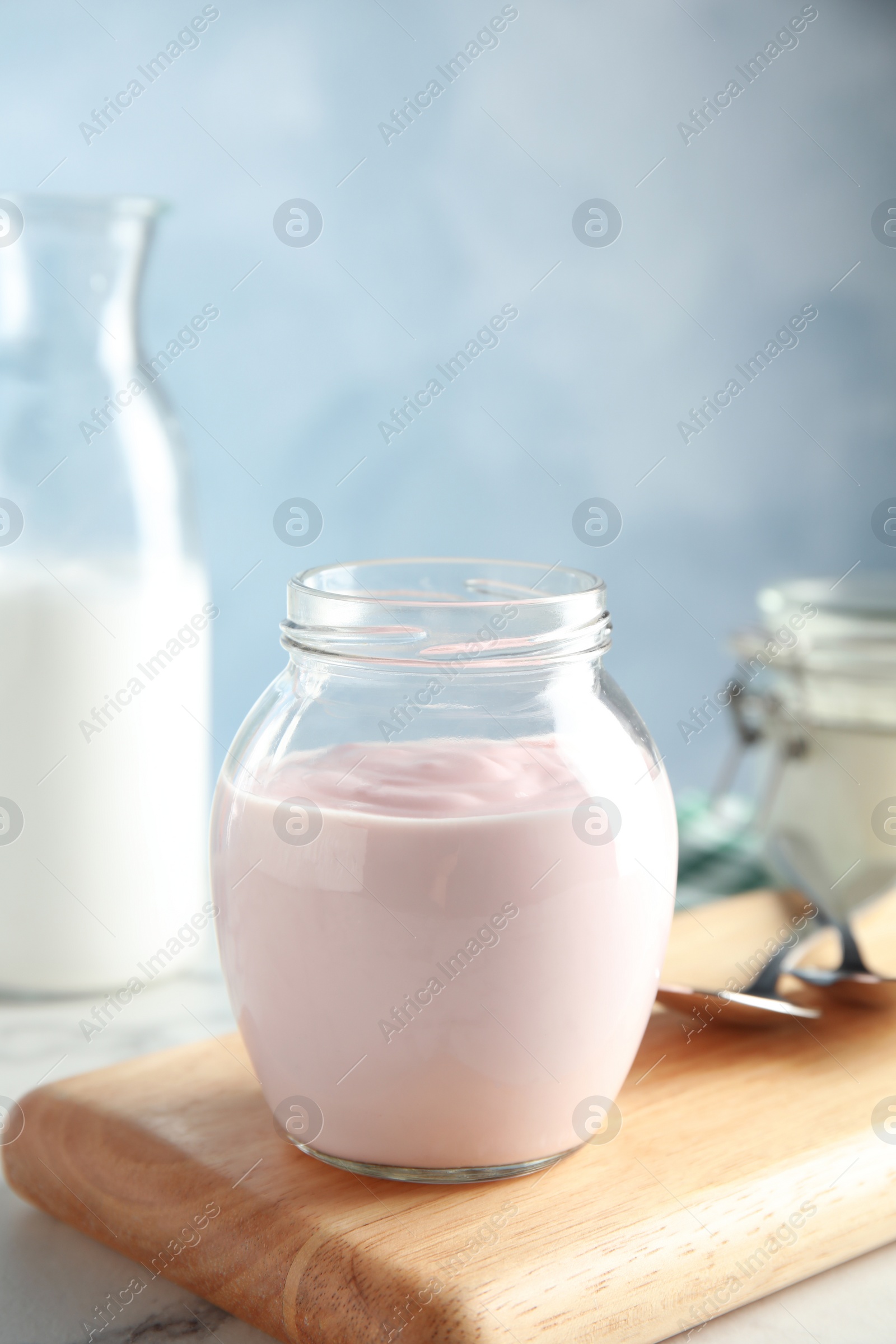 Photo of Glass jar of fresh yogurt on table. Space for text