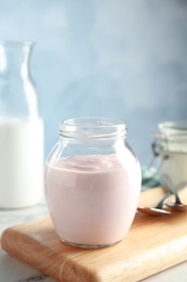 Photo of Glass jar of fresh yogurt on table. Space for text