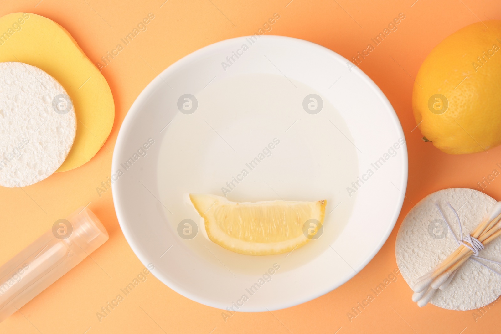 Photo of Lemon face cleanser. Fresh citrus fruits and personal care products on pale orange background, flat lay