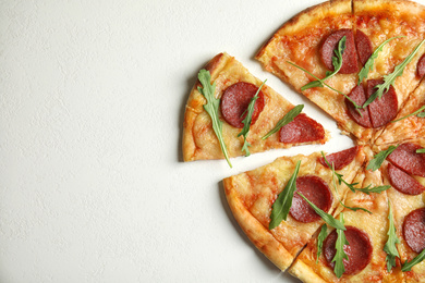 Photo of Tasty pepperoni pizza with arugula on white table, flat lay. Space for text