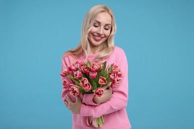 Beautiful young woman on light blue background