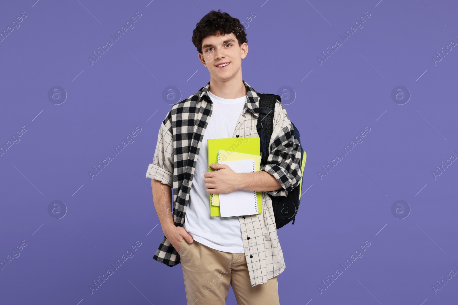 Photo of Portrait of student with backpack and notebooks on purple background