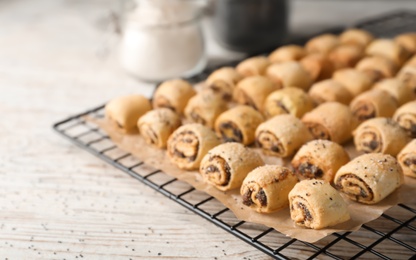 Photo of Tasty sweet cookies with poppy seeds on wooden table