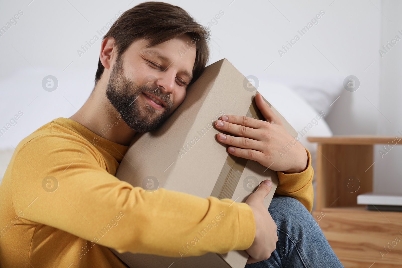 Photo of Happy man with parcel at home. Internet shopping