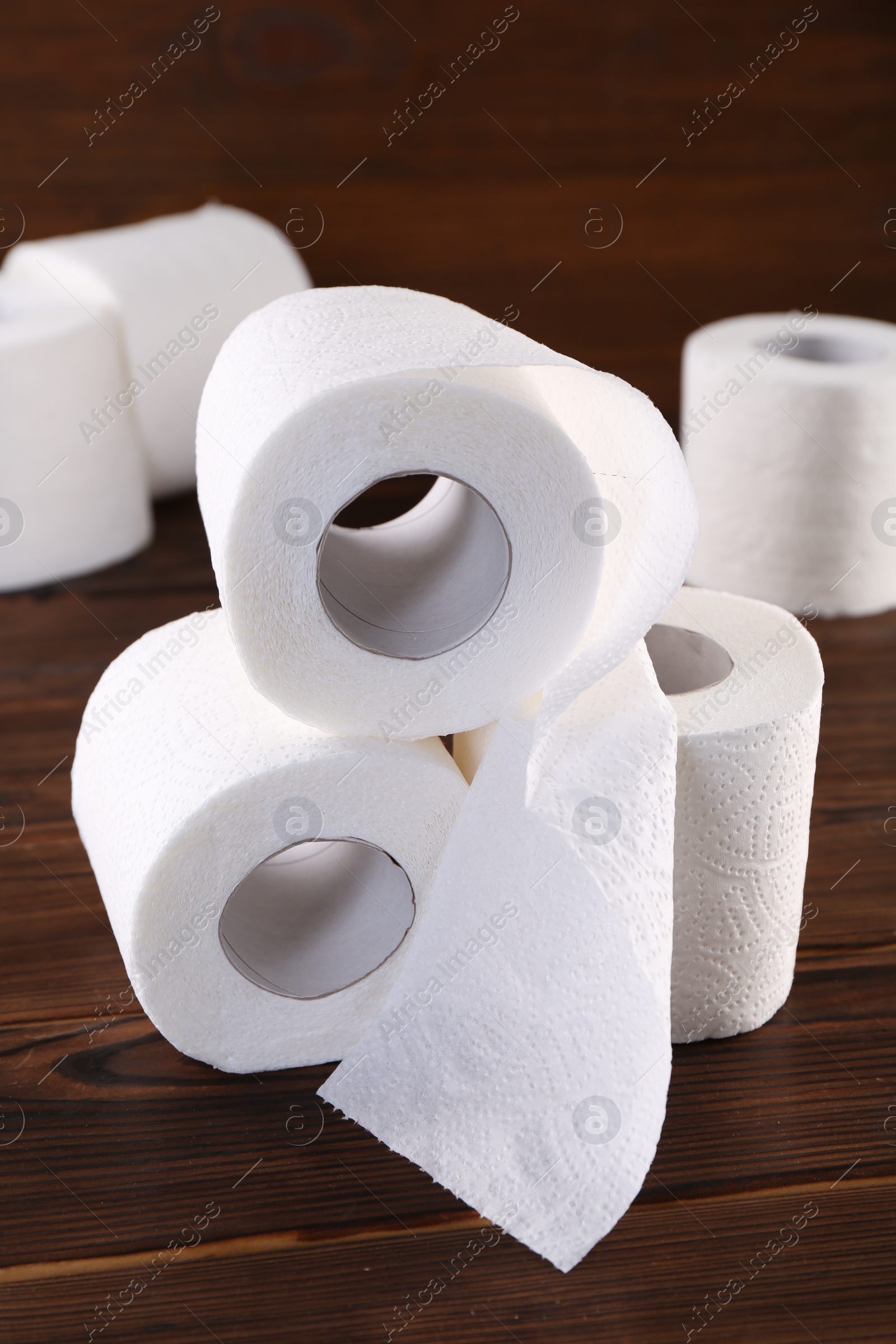 Photo of Many soft toilet paper rolls on wooden table