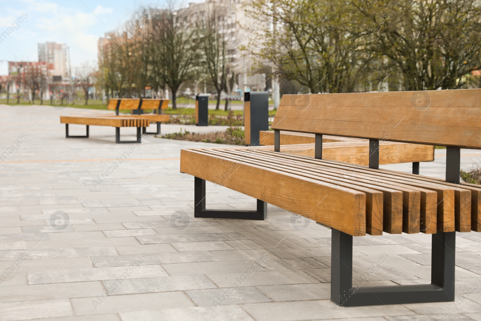 Photo of Paved city street with comfortable wooden benches