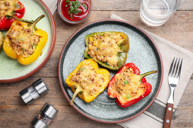 Photo of Tasty stuffed bell peppers served on wooden table