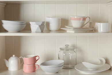 Stylish storage stand with different ceramic dishware at home