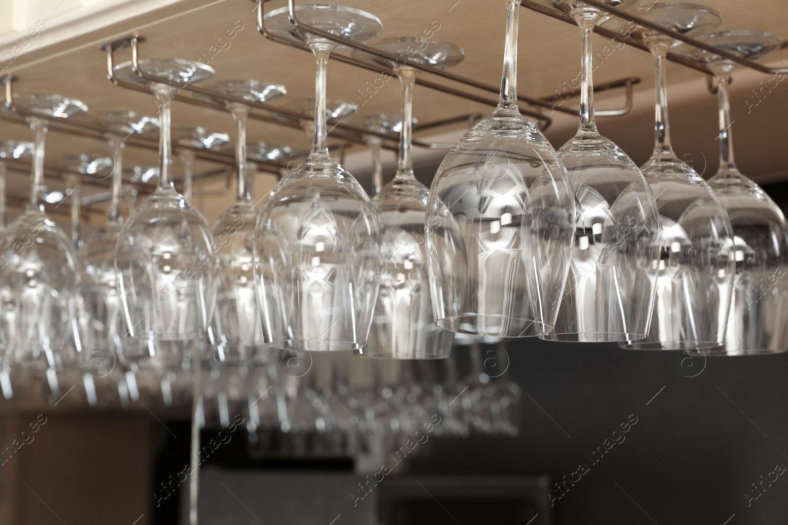 Photo of Set of empty clean glasses on bar racks