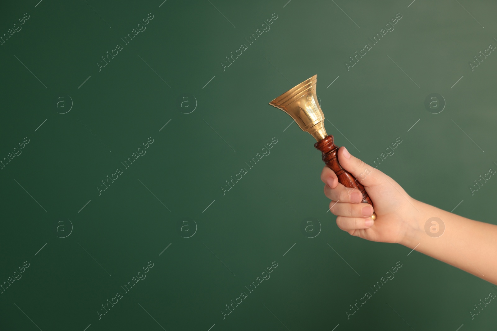 Photo of Pupil with school bell near chalkboard, closeup. Space for text