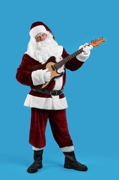 Photo of Santa Claus playing electric guitar on blue background. Christmas music