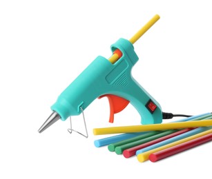 Turquoise glue gun and colorful sticks on white background