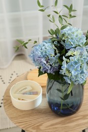 Beautiful blue hortensia flowers in vase on table indoors