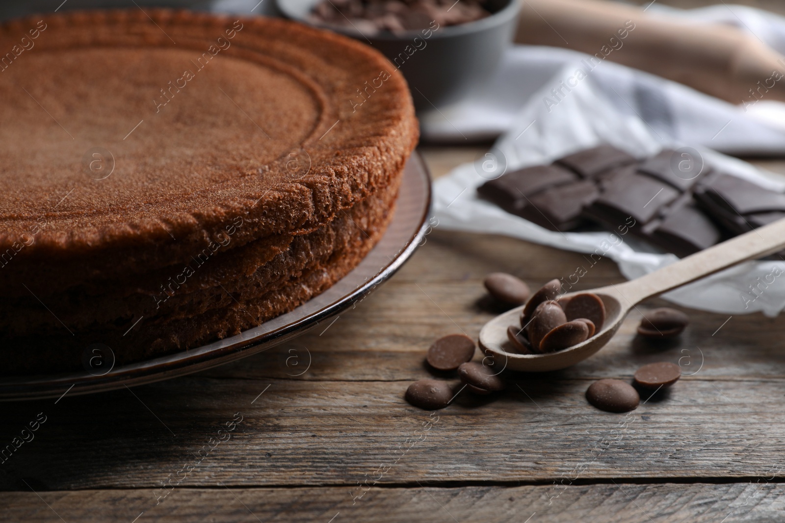 Photo of Delicious homemade sponge cake and different kinds of chocolate on wooden table, closeup