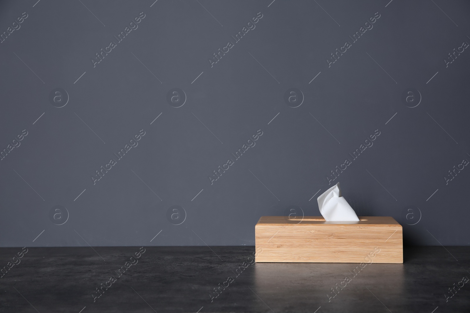 Photo of Napkin holder with paper serviettes on table against color background. Space for text