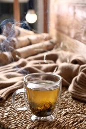 Photo of Wicker mat with freshly brewed tea in room. Cozy home atmosphere