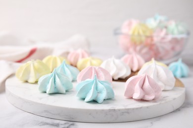 Photo of Tray with tasty meringue cookies on white marble table, closeup