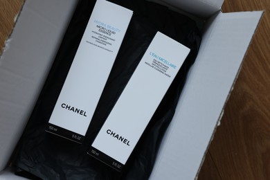 Photo of NETHERLANDS, LEIDEN - JULY 12, 2022: Chanel micellar water and micro liquid essence in box on wooden table, top view
