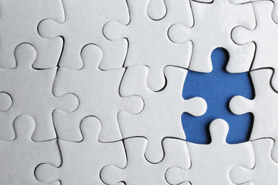 Photo of White puzzle with missing piece on blue background, top view. Career promotion concept