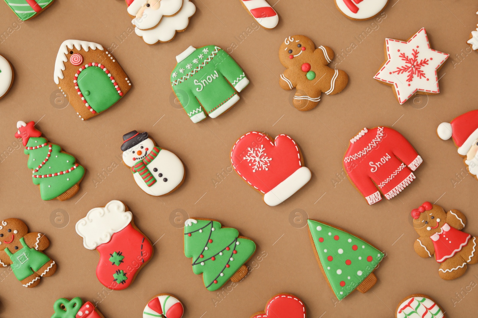 Photo of Different Christmas gingerbread cookies on brown background, flat lay