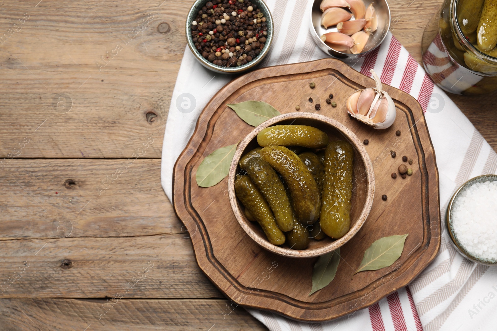 Photo of Tasty pickled cucumbers and spices on wooden table, flat lay. Space for text