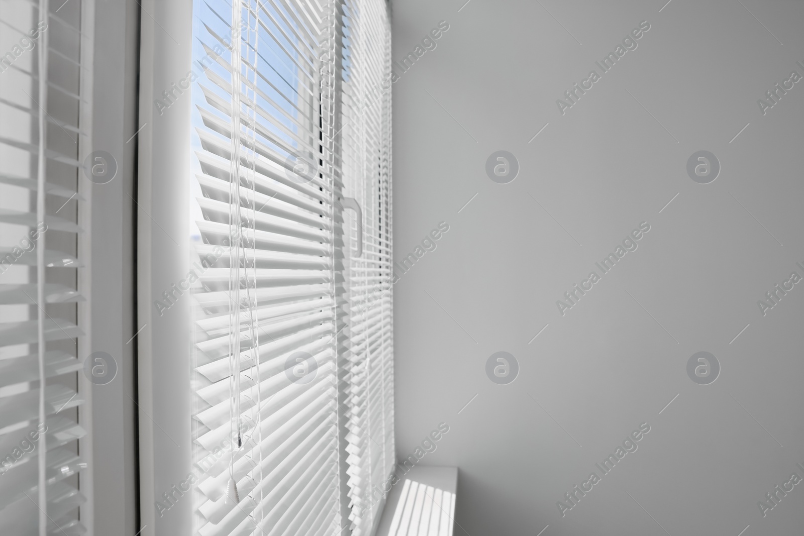 Photo of Stylish window with horizontal blinds in room