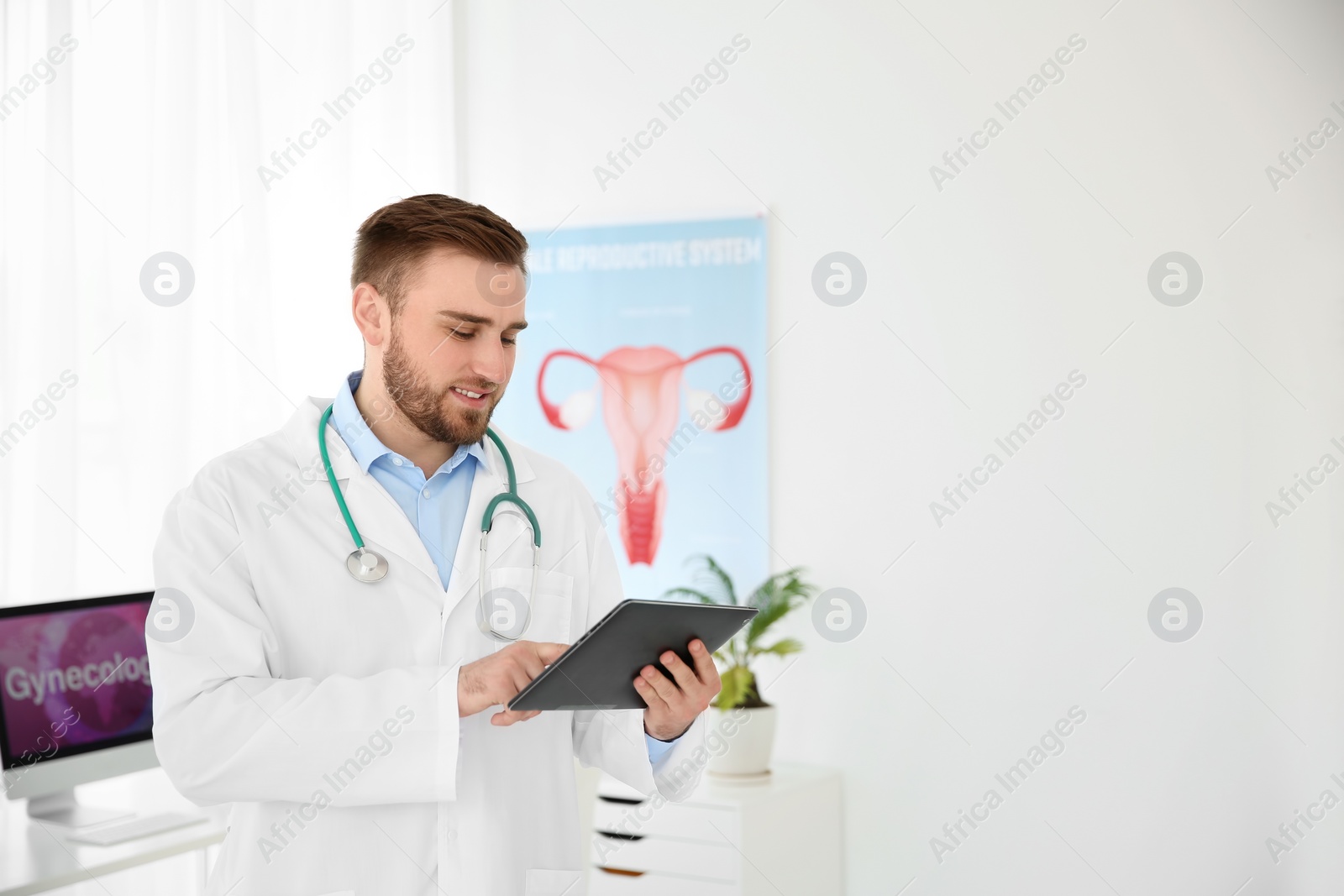 Photo of Young male doctor with tablet in modern hospital. Gynecology consultation