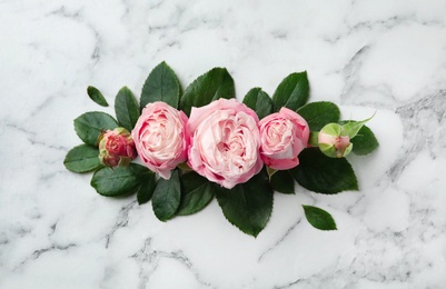 Beautiful roses on marble background, top view